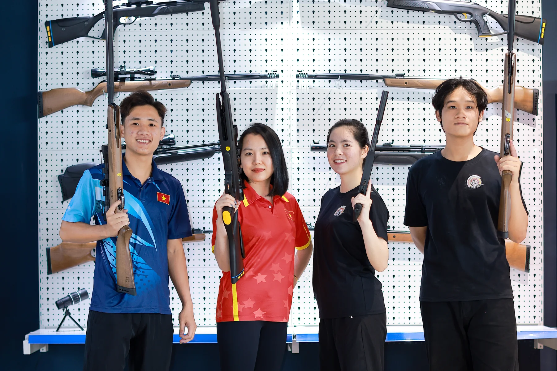 Staff team posing with rifles at the indoor armoury