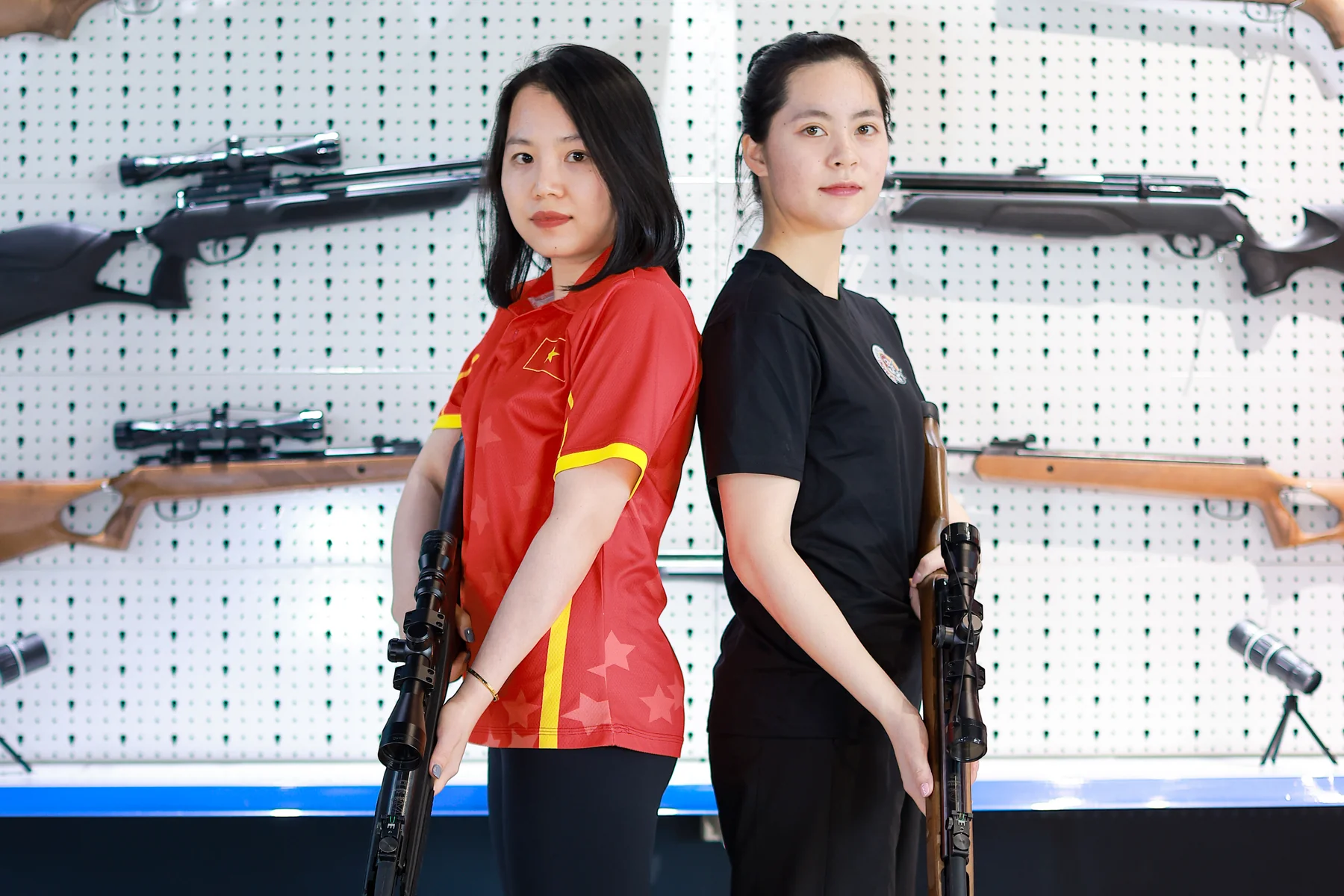 Staff pair holding rifles upright at the rifle wall