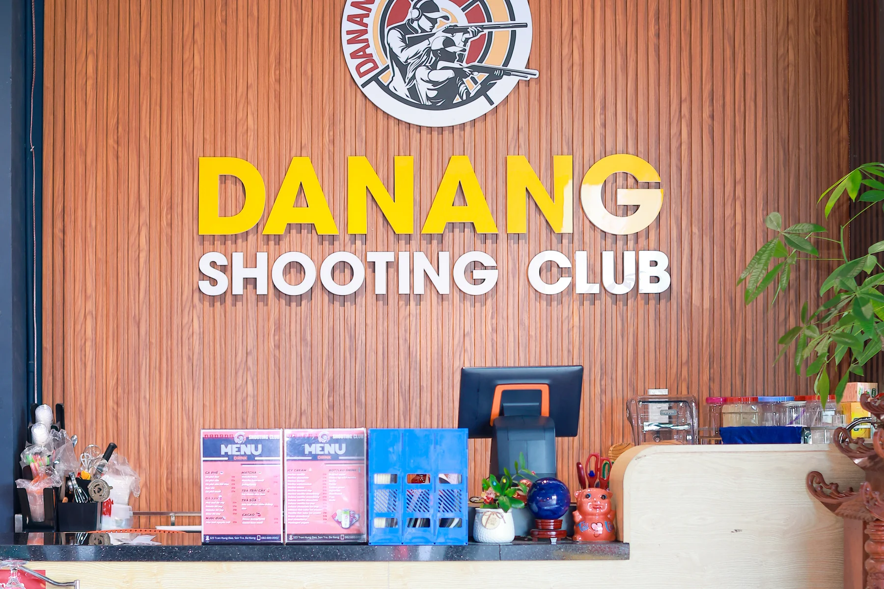 Reception counter with DANANG SHOOTING CLUB logo